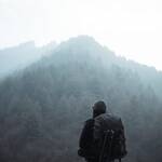 a person standing on a rock looking at a mountain range