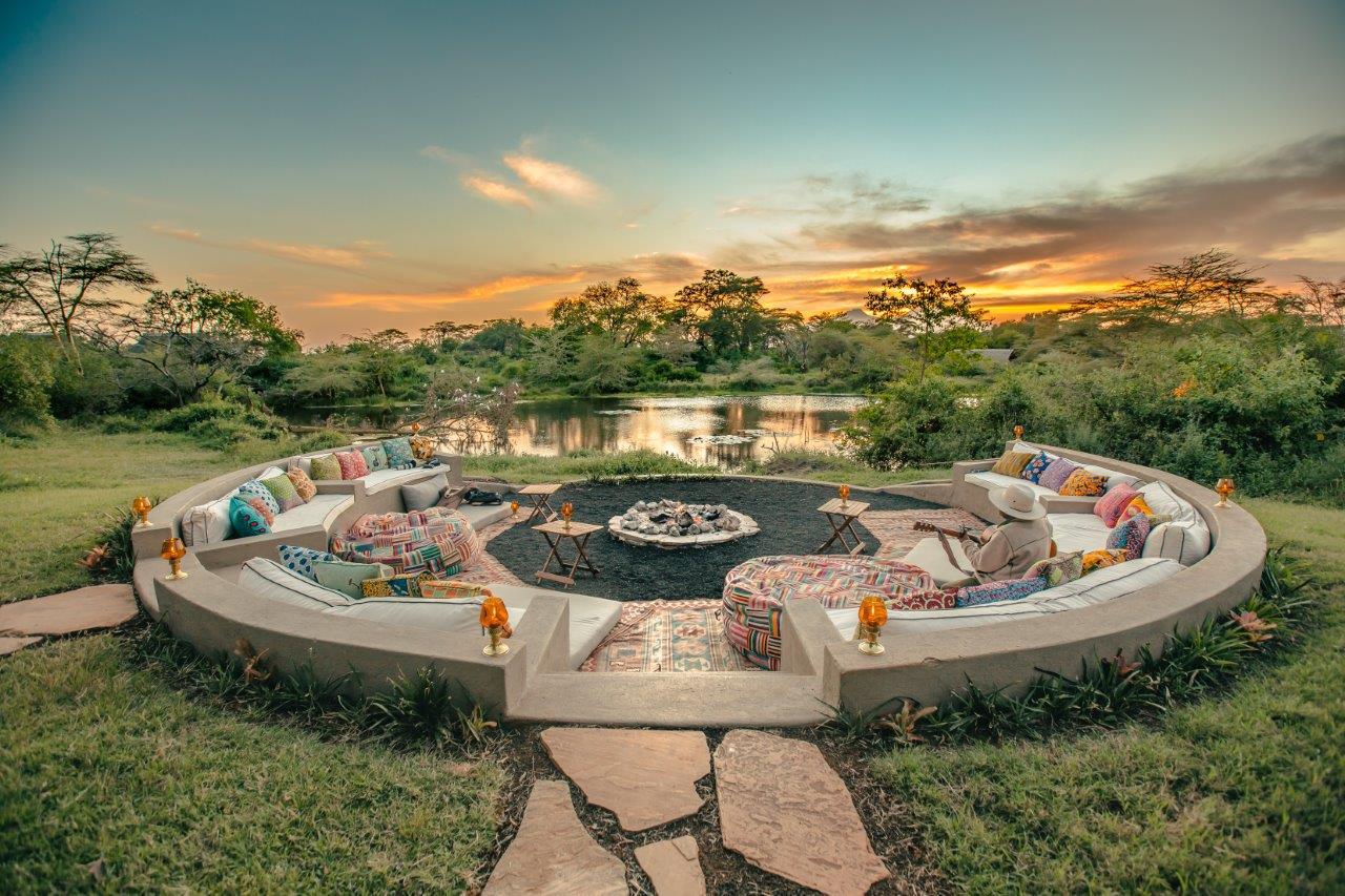 a circular patio with a fire pit and a large couch of Finch Hatton